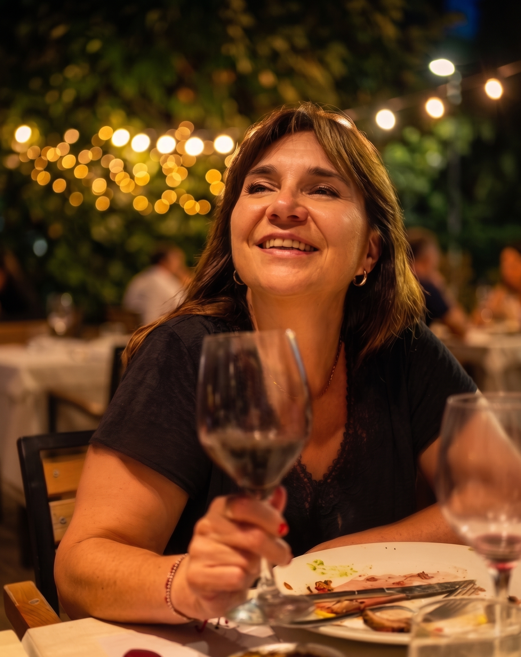 Marcela Berón sonriendo con una copa de vino Pinot Noir
